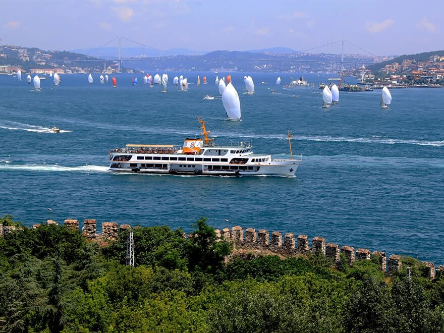 Lautta ylittää Bosporinsalmea Istanbulissa taustallaan paljon purjeveneitä