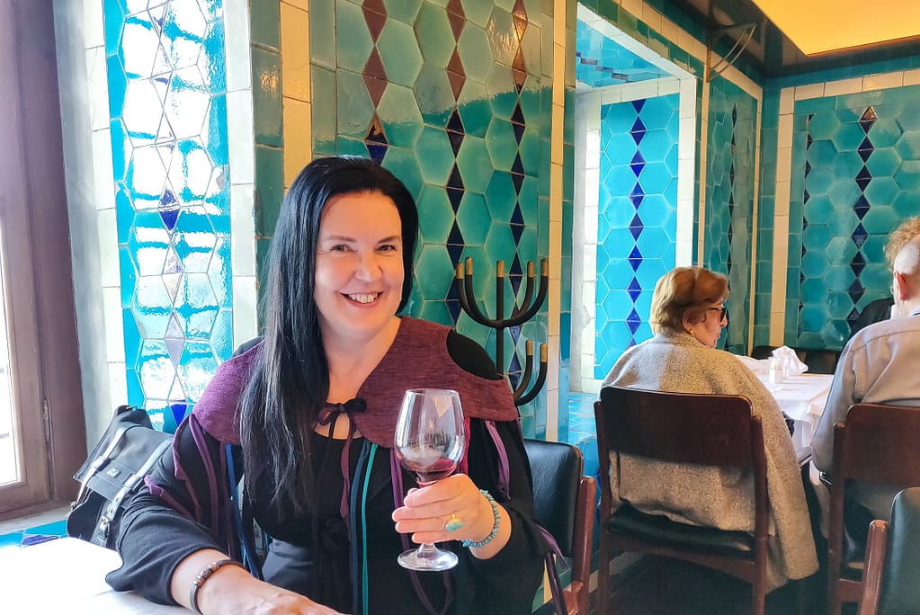 A happy foodie blogger, Anne Özay, in the historical setting of Restaurant Pandeli in Istanbul.