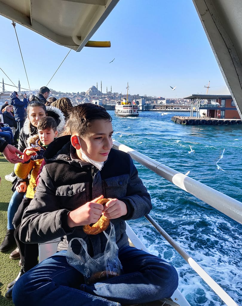 The boy is feeding seagulls on our Bosphorus Cruise in Istanbul.